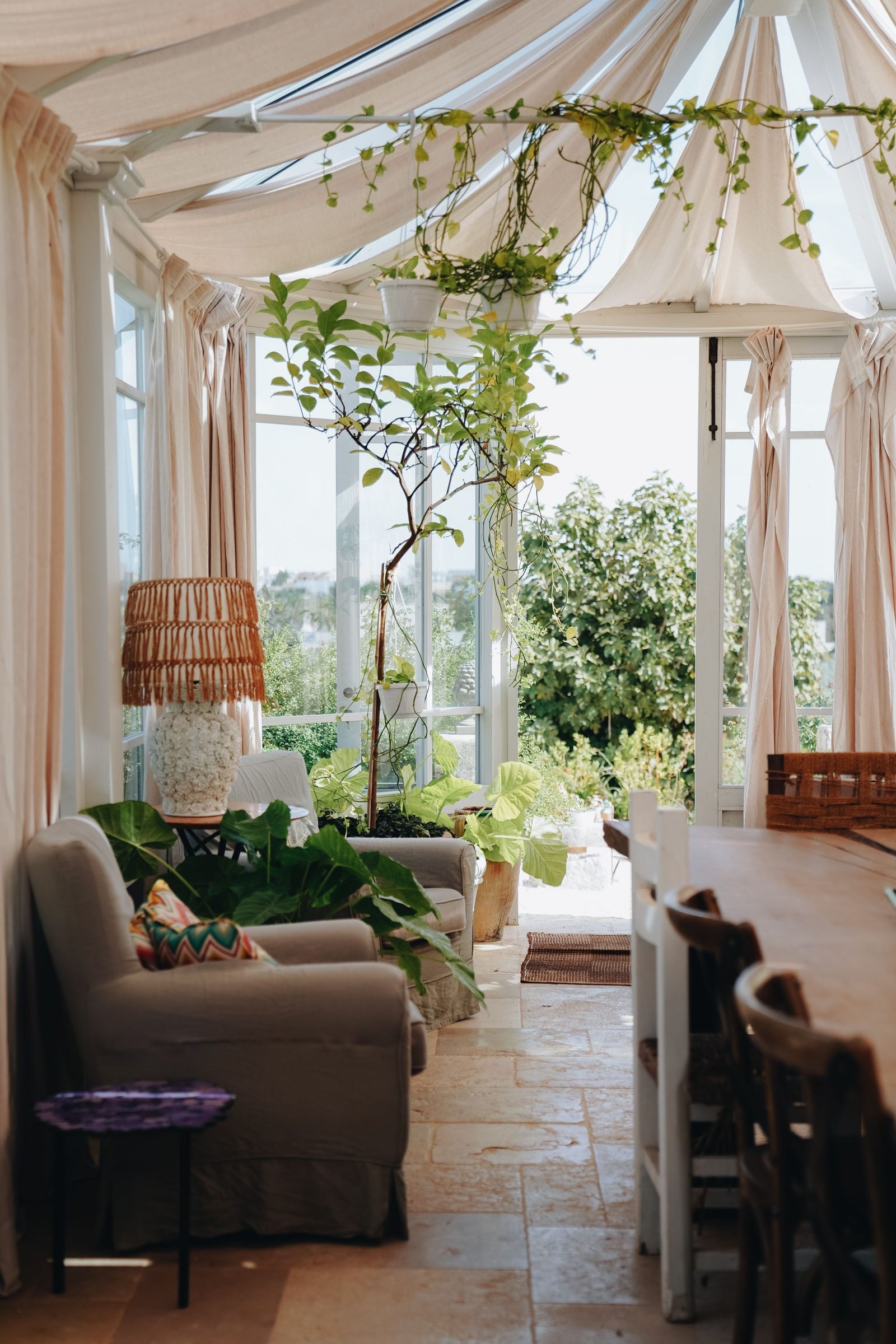 Bright Edwardian style conservatory interior with plants and garden view